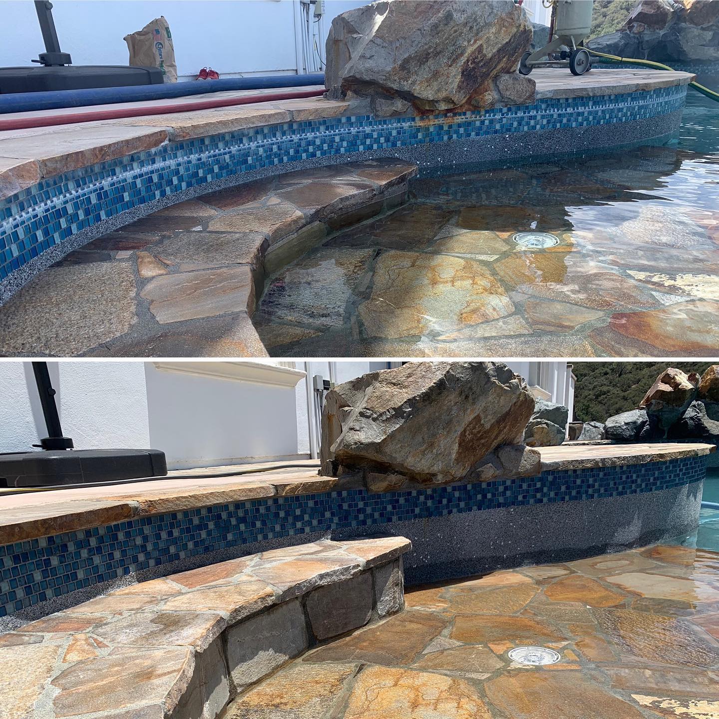 Stone-lined swimming pool with large rocks and blue mosaic tile border